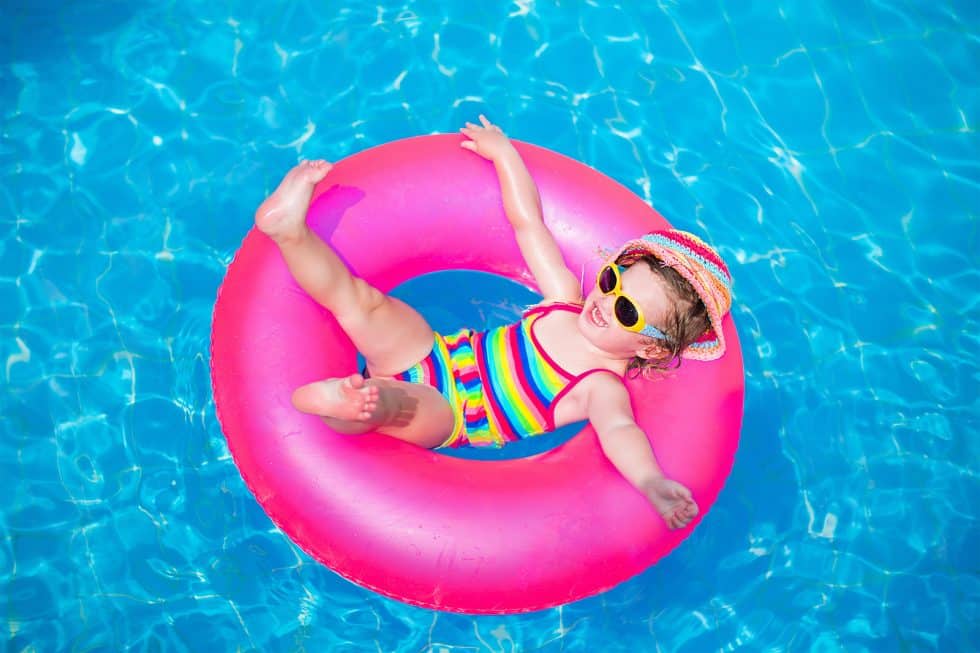 Vacation Travel Innovation Reviews family travel image featuring a child relaxing in a resort pool.